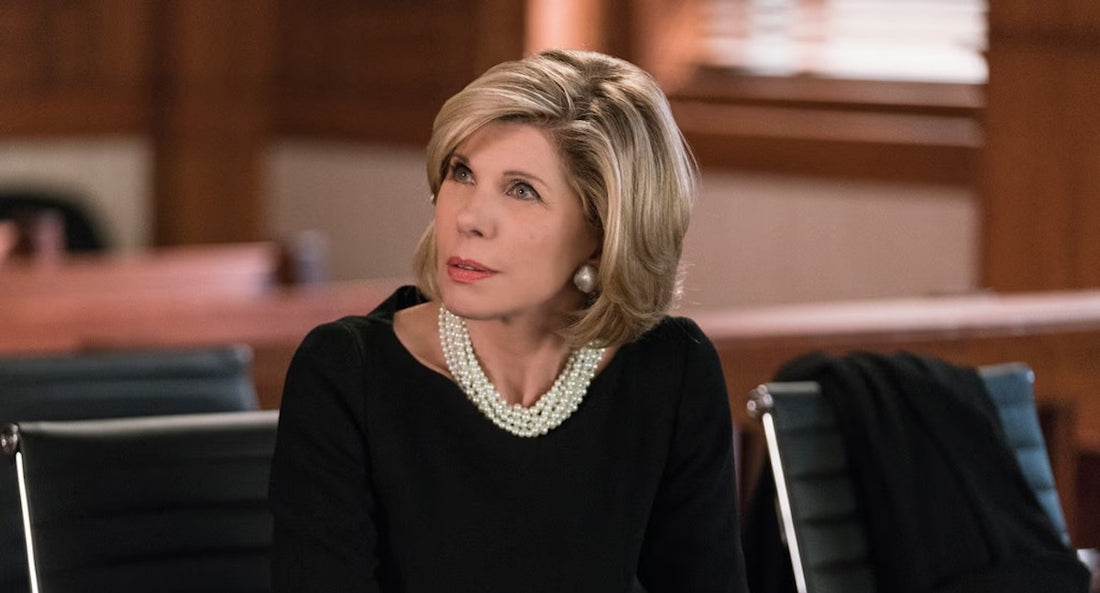 Diane Lockhart wearing a black outfit with statement multi-strand pearl necklace and pearl earrings